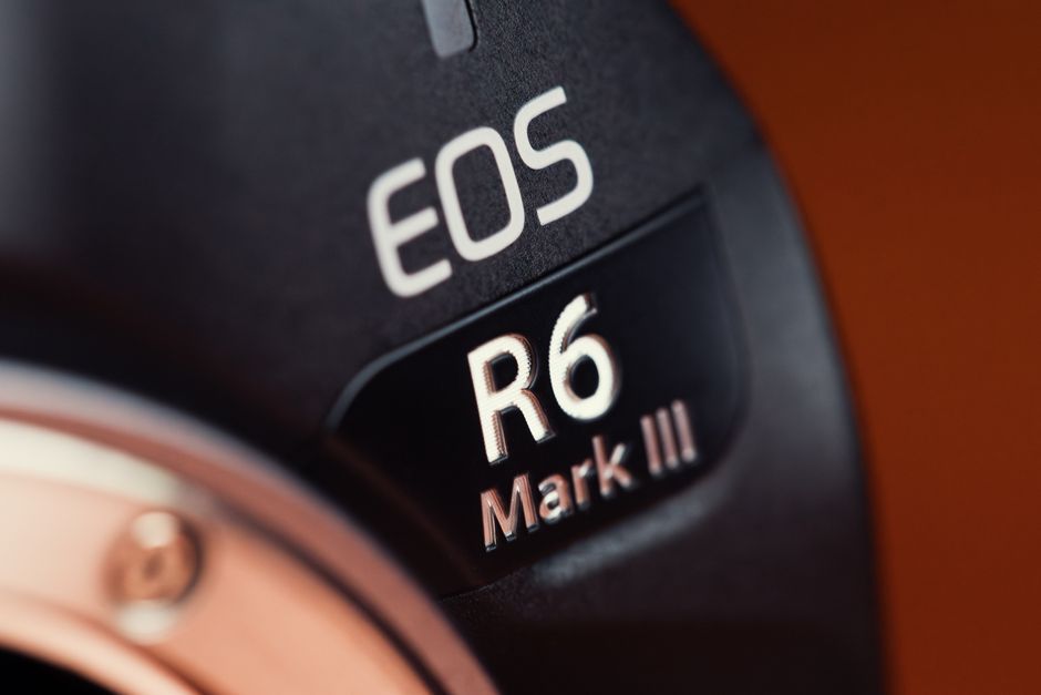 Detailed macro shot of a modern camera lens with EOS branding, emphasizing technology and innovation.