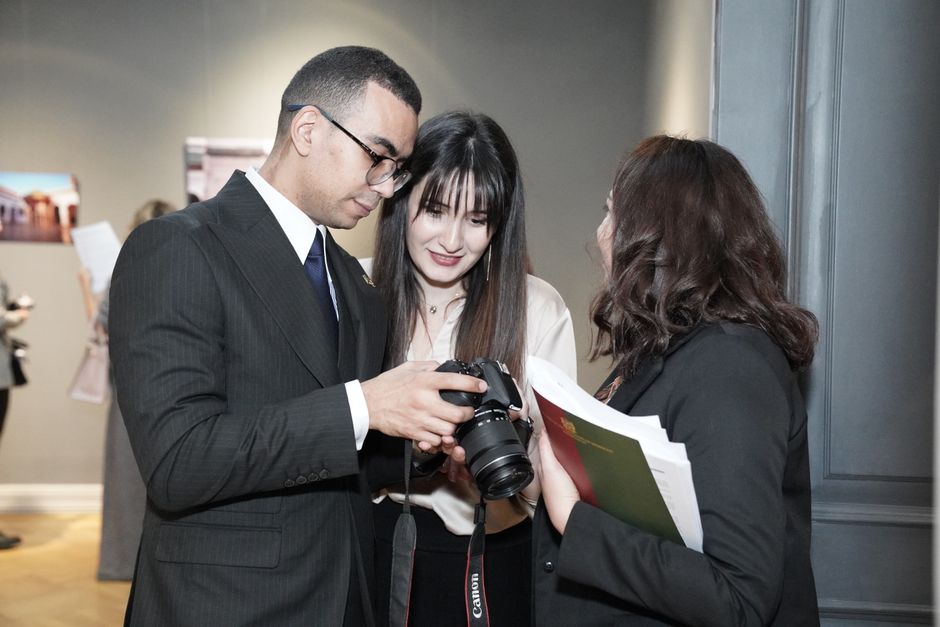 Professionals interacting at a conference, sharing camera insights with a lively discussion.