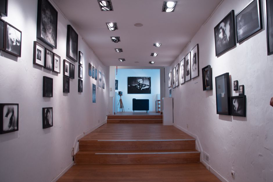 Stylish art gallery interior featuring steps and framed pictures on white walls, creating a serene atmosphere.